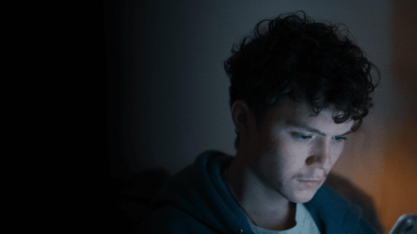 isolated young man looking at his phone